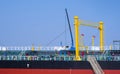 Oil pipeline system with crane machinery in tanker ship while moored at harbor against blue sky background Royalty Free Stock Photo