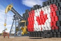 Oil production and extraction in Canada. Oil pump jack and oil barrels with UCanadian flag