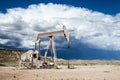 Oil pump in desert landscape with dark clouds looming in the background