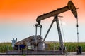 Oil pump jack against an open sky in a rural midwest corn field Royalty Free Stock Photo