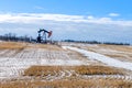 A oil pump jack in an agriculture field at winter season Royalty Free Stock Photo