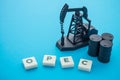 Oil pump jack, barrels and word OPEC Organization of the Petroleum Exporting Countries on blue background. Concept of crude oil