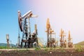 Oil pump jack rocking with pipeline in the background. Rocking machines for power generation. Extraction of oil. Royalty Free Stock Photo