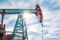 Oil pump jack rocking with pipeline in the background. Rocking machines for power generation. Extraction of oil. A Royalty Free Stock Photo