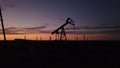 Oil pump machine crane with sun in the background in contre-jour