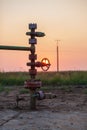 Oil pump valve at sunset Royalty Free Stock Photo