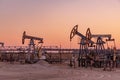 Oil Pumpjack against a sunset sky on background. industrial equipment. Rocking machines for power genertion. Extraction Royalty Free Stock Photo