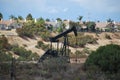 Oil pumpjack derrick next to residential neighborhood