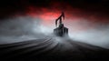 Oil pumpjack silhouette against dramatic red sky on sand dune Royalty Free Stock Photo