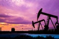 Oil pumps at oil field with sunset sky background