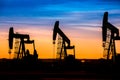 Oil pumps at oil field with sunset sky background