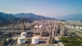 Oil refinery with a background of mountains and sky.The factory is located in the middle of nature, Generative AI Royalty Free Stock Photo