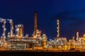 Oil refinery illuminated at night, with numerous pipelines and storage tanks depicting fossil fuel industry Royalty Free Stock Photo