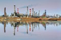 Oil refinery at night with reflection in water