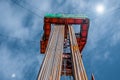 Oil rig derrick in oilfield against the bright blue sky. Drilling rig in oil field for drilled into subsurface in order