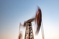 Oil rig silhouette working at sunset. Blur at slow shutter speeds Royalty Free Stock Photo