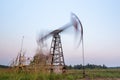 Oil rig silhouette working at sunset. Blur at slow shutter speeds Royalty Free Stock Photo