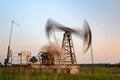 Oil rig silhouette working at sunset. Blur at slow shutter speeds Royalty Free Stock Photo