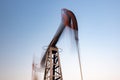 Oil rig silhouette working at sunset. Blur at slow shutter speeds Royalty Free Stock Photo