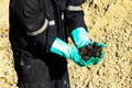 Oil sands development from an oil drilling district. The hand on the oil sands. Operator take oil sand s sample from mine Royalty Free Stock Photo