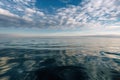 oil slick on calm ocean, with serene sky and reflections
