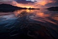 oil slick in the water and against a serene sunset backdrop