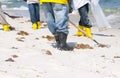 Oil spill workers cleaning beach Royalty Free Stock Photo