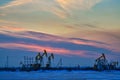 The oil sucking machines sunset in winter in Daqing oil fields Royalty Free Stock Photo