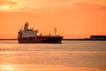 Oil tanker coming into a harbour at sunset Royalty Free Stock Photo