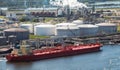 Oil tanker moored an oil terminal with fuel storage silos in an industrial port Royalty Free Stock Photo