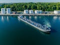 Oil tanker sailed out from an oil storage silo terminal after unloading. Aerial view of oil tankers and storage silo tanks at a pe Royalty Free Stock Photo