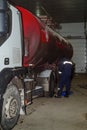 An oil tanker is undergoing maintenance at a service station