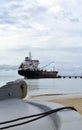 Oil tanker vessel at dock with boat bow in foreground anchor pu Royalty Free Stock Photo