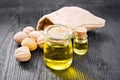 Oil walnut in jar and bottle on dark board Royalty Free Stock Photo