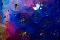 Oil on a water surface with bubbles and pieces of Gold leaf. Abstract colorful background. Close-up, not illustration Royalty Free Stock Photo