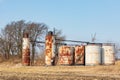 Old oil well storage tanks in farm field. Royalty Free Stock Photo