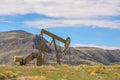 Oil Well Against Mountains and Blue Cloudy Sky