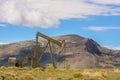 Oil Well Against Mountains and Blue Cloudy Sky