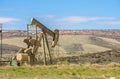 Oil Well Against Mountains and Blue Cloudy Sky Spring Scene