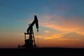 Oil Well Silhouetted Against Prairie Sunset Royalty Free Stock Photo