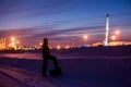 Oil worker in oilfield. Pump jack and engineer on a winter sunset sky background. Western Siberia.
