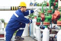 Oil worker is turning valve on the oil pipeline Royalty Free Stock Photo