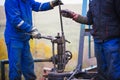 Oil workers check oil pump. Roustabouts doing dirty and dangerous work Royalty Free Stock Photo