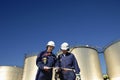 Oil workers and refinery tanks Royalty Free Stock Photo