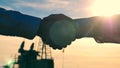 Oilmen handshake in an oilfield. Close up