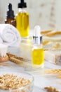 Oils, bath brush, towel and wheat sprouts on the cosmetic table in the bathroom. A set of organic cosmetics in glass vials with