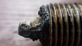 Oily and charred car sparkplug macro photo