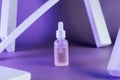 Oily serum in glass bottle with pipette on purple background with rectangle arch and columns , neon light with copy Royalty Free Stock Photo