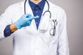 Ointment for skin. Handsome young medic doctor with a stethoscope, isolated over grey background