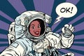 OK gesture woman astronaut in a spacesuit